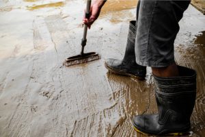 Concrete floors being prepared by a worker