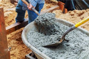 Concrete wall stabilization with workers and a trolley and shovels